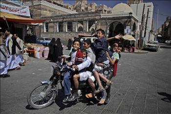 يمنيون يستقلون دراجة نارية في أحد أحياء صنعاء القديمة أمس 