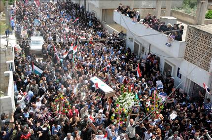 سوريون يشيّعون عنصراً من الشرطة قتل في حمص أمس (أ ف ب) 