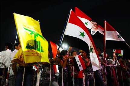 مناصرون للأسد يحملون أعلام سوريا و«حزب الله» خلال الاحتفال بعيد ميلاده في باب توما في دمشق أمس (رويترز) 