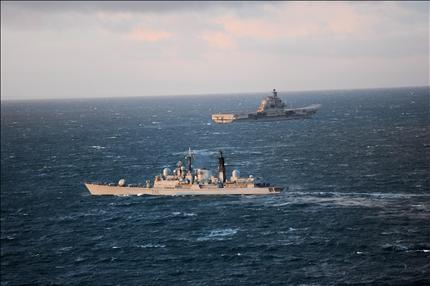 حاملة الطائرات الروسية «الأميرال كوزينتسوف» في الخلف ومدمرة في المياه الدولية قبالة اسكتلندا أمس الأول، في طريقهما إلى البحر المتوسط (رويترز) 