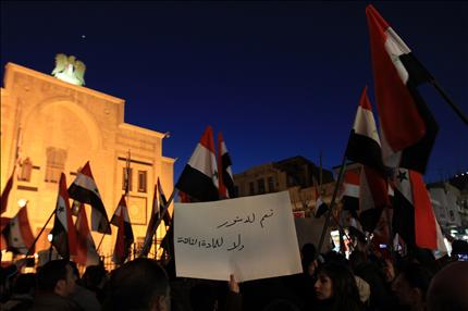 سوريون يتظاهرون أمام البرلمان السوري في دمشق أمس للمطالبة بإلغاء المادة الثالثة من الدستور الجديد (أ ف ب) 