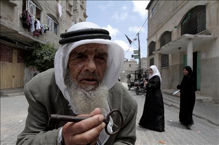 فلسطيني يحمل مفتاح داره التي هجر منها، في مدينة رفح في قطاع غزة أمس (أ ف ب) 