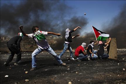فلسطينيون خلال المواجهات مع قوات الاحتلال أمام سجن عوفر قرب رام الله أمس (أ ب) 