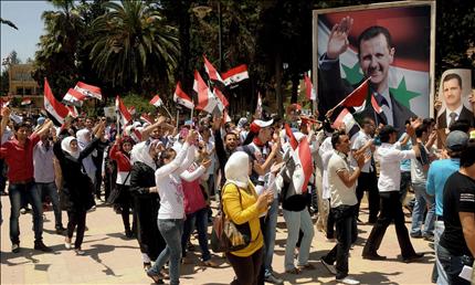 طلاب يحملون صور الأسد في جامعة حلب أمس (أ ب أ) 