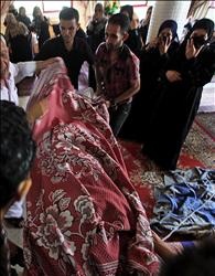 أقارب الشهيد محمد أبو معيلق ينتحبون فوق جثمانه في دير البلح في وسط قطاع غزة أمس (أ ب أ) 