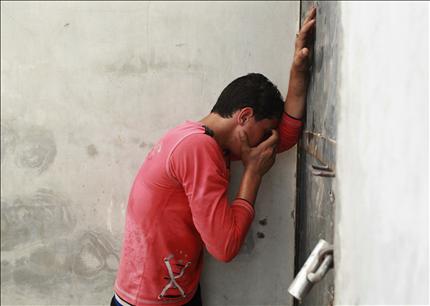 فلسطيني يبكي على الشهيد الهيقي في غزة أمس (رويترز) 
