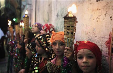 فتيات فلسطينيات يحملن مشاعل خلال احتفالات بعد الإفطار في القدس المحتلة أمس الأول (رويترز) 