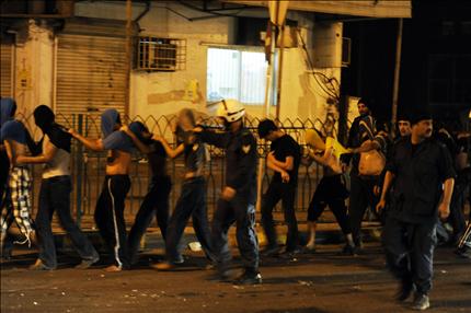 عناصر من الشرطة البحرنية يقتادون معتقلين بتهمة التظاهر ضد الحكومة في قرية بني جمرة امس (رويترز) 