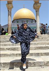 فتاة فلسطينية تركض أمام مسجد قبة الصخرة في القدس المحتلة أمس (ا ب ا) 