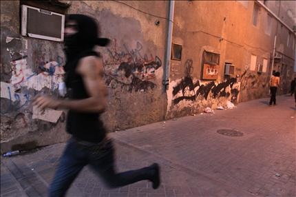  معارض بحريني يهرب من الشرطة في جزيرة المحرق، أمس الأول. (أ ب) 