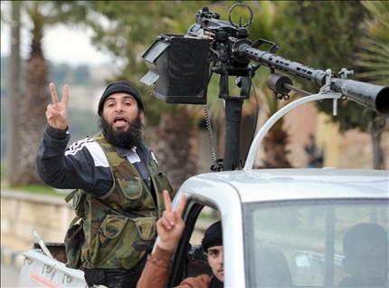 مسلحان يرفعان شارة النصر بعد سيطرتهم على قرية الجنودية في ريف ادلب امس (ا ف ب) 