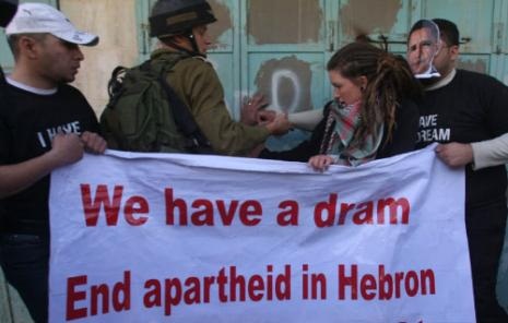 يمنع محتجين من رفع لافتة ضد عنصرية اسرائيل في الخليل أمس (حازم بدر ــ أ ف ب) 