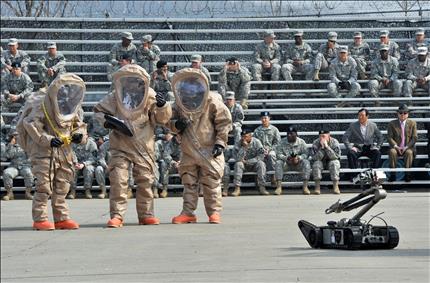 جنود أميركيون من الكتيبة الـ23 لمكافحة الكيميائي يستعرضون، أمس، معداتهم في كوريا الجنوبية،التي كانت غادرتها في العام 2004. (أ ف ب) 