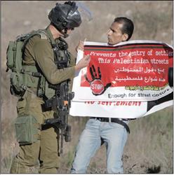 فلسطيني يواجه جندياً إسرائيلياً خلال تظاهرة احتجاجاً على إغلاق شوارع قرية القريوت لصالح المستوطنين قرب نابلس أمس الأول (أ ف ب) 