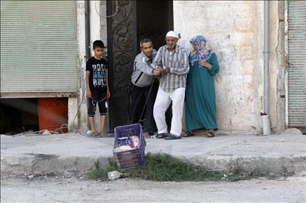 سوريون يسحبون سلة تحوي مواد غذائية حصلوا عليها من ناشطين في الاشرفية في حلب امس (رويترز)