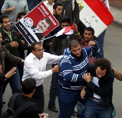 عناصر من جماعة الإخوان المسلمين يهاجمون متظاهراً مصرياً أمام قصر الاتحادية في القاهرة أمس (أ ب أ) 