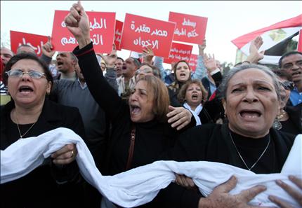 مصريات متشحات بالسواد يحملن أكفانهن في مقدمة مسيرة القوى الثورية إلى قصر الرئاسة في القاهرة أمس (أ ب أ) 