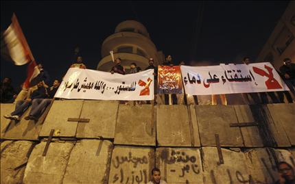 متظاهرون ضد مرسي يرفعون لافتات تندّد بالدستور أمام القصر الرئاسي في القاهرة أمس (رويترز) 