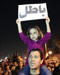 طفلة تحمل لافتة «باطل» خلال تظاهرة في القاهرة (رويترز) 