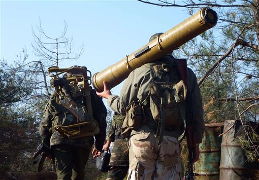 مسلح يحمل مضاداً للدبابات وآخر قاعدة الإطلاق خلال توجههما إلى المواقع الأمامية في بلدة كسب في ريف اللاذقية الشمالي امس (رويترز)