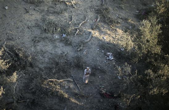 فلسطيني يقف حيث كان منزله الذي دمرته غارة إسرائيلية على غزة أمس (رويترز)