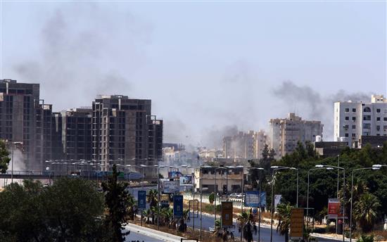 تصاعد دخان في المنطقة المحيطة بمطار طرابلس الدولي نتيجة المعارك بين الميليشيات المتحاربة للسيطرة عليه (أ ف ب)