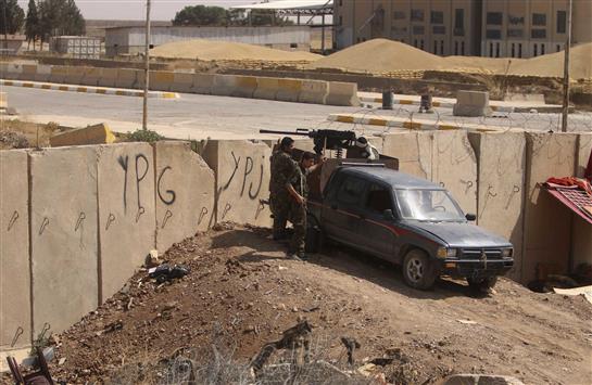 مقاتلون من "وحدات حماية السعب" الكردية تتمركز عند معبر ربيعة الحدودي مع العراق أثناء مواجهات مع تنظيم "داعش"، أمس.(رويترز)