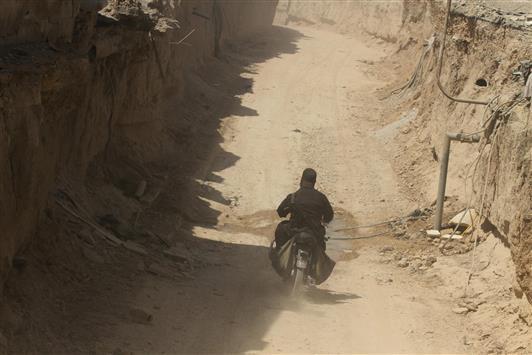 مسلح على دراجة نارية في «نفق» يربط بين زملكا وجوبر في ريف دمشق امس (رويترز)