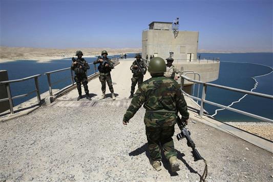 مجموعة من قوات "البشمركة" تتولى حراسة سد الموصل بعد السيطرة عليه بشكل كامل، أمس الأول.(رويترز)