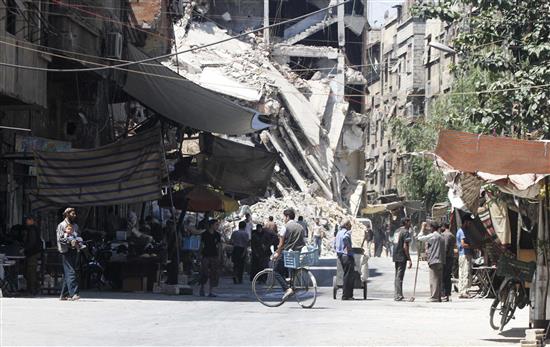مقيمون في حرستا في ريف دمشق خلال تبضعهم أمس الأول (رويترز)