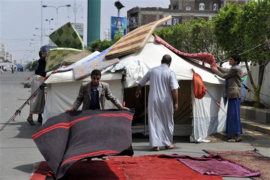 مؤيدون للحوثيين يعيدون ترتيب خيم الاعتصام أمام وزارة الداخلية اليمنية في صنعاء أمس (أ ف ب)