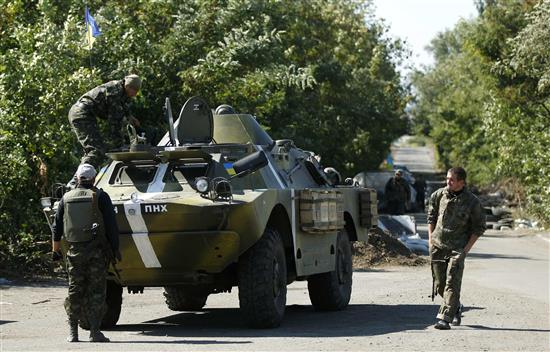 عناصر من الجيش الأوكراني يتمركزون أمام حاجز لهم في بلدة هورليفكا في شرق أوكرانيا أمس (رويترز)