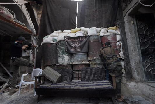 مسلحان من «الجبهة الاسلامية» خلف متراس في المدينة القديمة في حلب امس الاول (رويترز)