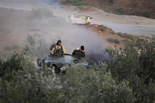 مسلحان على متن دبابة في كفرزيتا في ريف حماه امس الاول (رويترز)