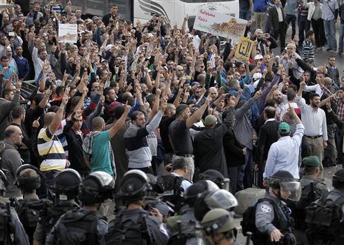 فلسطينيون يتظاهرون أمام المسجد الأقصى ضد قرار الاحتلال بمنع دخول المصلين في القدس المحتلة أمس (أ ف ب)