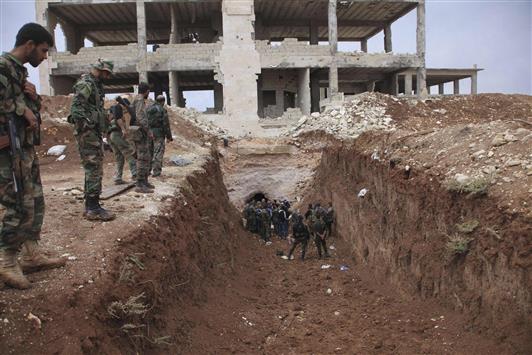 جنود سوريون يتفحصون نفقاً في قرية الجبيلة في ريف حلب أمس (رويترز)