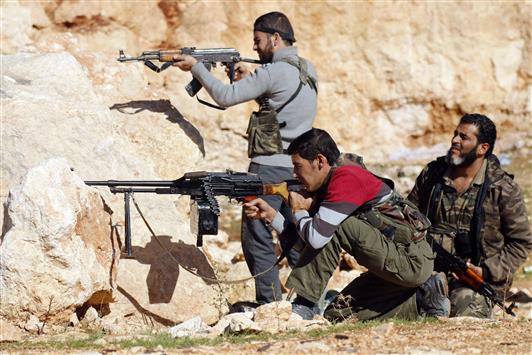 مسلحون خلال اشتباكات مع الجيش السوري في منطقة حندرات في ريف حلب امس (رويترز)