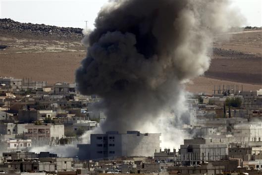 دخان يتصاعد من عين العرب امس جراء غارة جوية (رويترز)