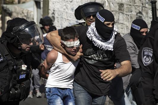 مستعرب وعناصر من شرطة الاحتلال يعتقلون فتى فلسطينياً خلال الموجهات في حي الجوز في القدس الشرقية أمس (رويترز)