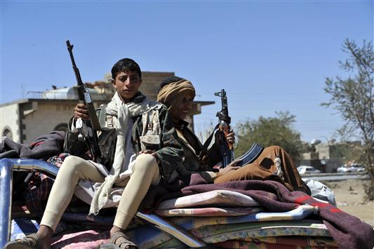 مسلحان حوثيان يجلسان على سيارة محملة بتجهيزات خيم قاموا بتفكيكها في العاصمة صنعاء أمس (أ ب أ)