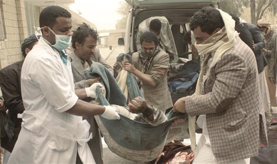 يمنيون يحملون رجلاً قُتل جراء غارة جوية استهدفت سوقاً في صعدة الشمالية أمس (رويترز)