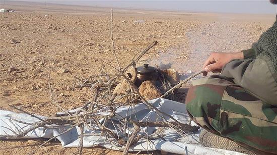 جندي سوري يعدّ الشاي على الحطب