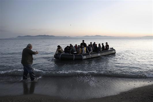 يوناني يحاول مساعدة لاجئين سوريين قبالة سواحل اليونان. ( ا ب ا)