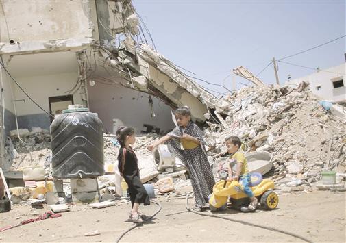 أطفال يلهون أمام منزلهم المدمر في غزة أمس (ا ف ب)