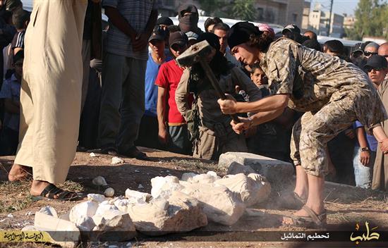 عنصر من "داعش" يحطم تماثيل مسروقة من تدمر امس الاول (ا ف ب)