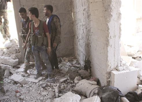 عناصر من الجيش السوري قرب جثة احد المسلحين في حلب امس الاول (ا ف ب)