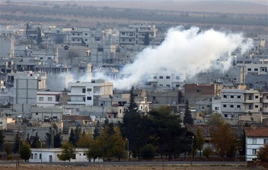 دخان يتصاعد من مدينة عين العرب خلال الاشتباكات بين المقاتلين الأكراد وعناصر "داعش" أمس (رويترز)