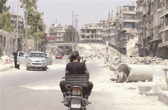مسلحان على دراجة نارية قرب جسر الشعار في حلب امس الاول (رويترز)