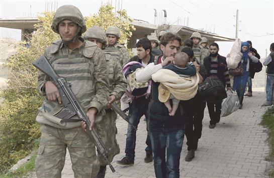 جنود اتراك يحيطون بعائلة سورية عبرت الحدود امس (رويترز)