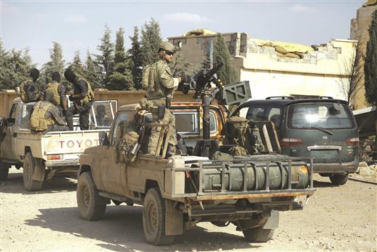جندي أميركي مع عناصر من «قوات سوريا الديموقراطية» في قرية الفاطسة شمال الرقة أمس الأول (ا ف ب)